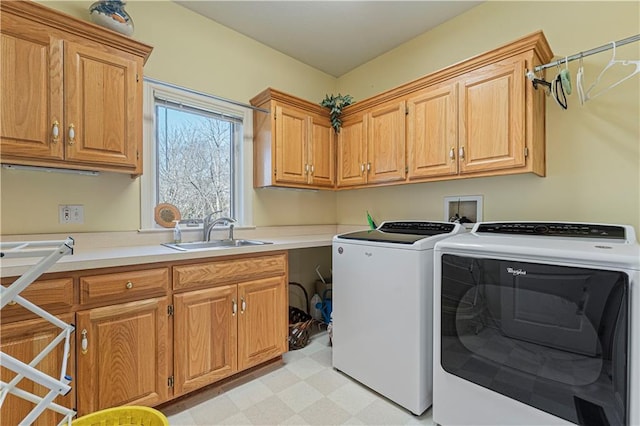washroom featuring washer and dryer, cabinet space, light floors, and a sink