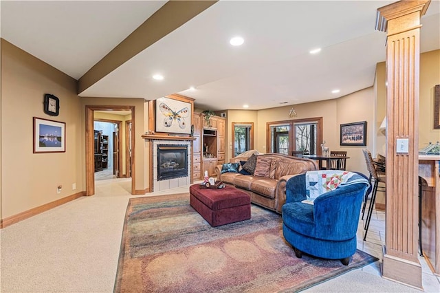 living room with recessed lighting, light colored carpet, a tile fireplace, and baseboards