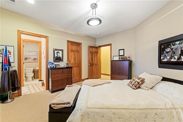 carpeted bedroom with visible vents and ensuite bath