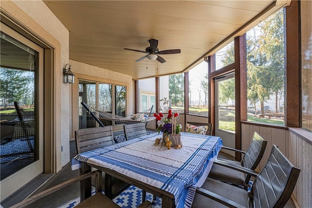 sunroom / solarium with outdoor dining area and a ceiling fan