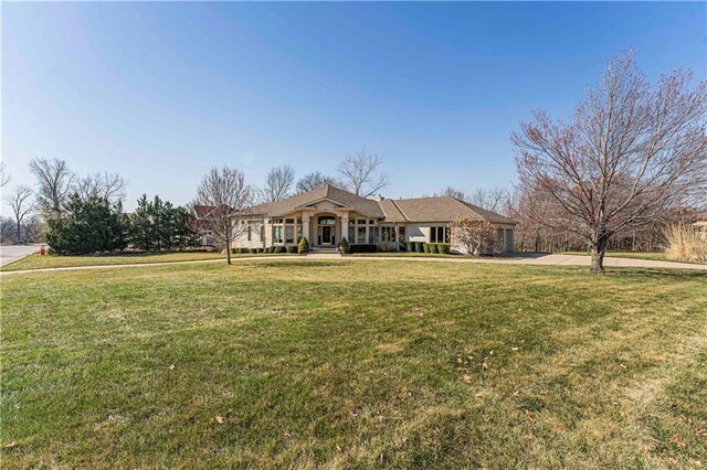 view of front of home featuring concrete driveway and a front lawn