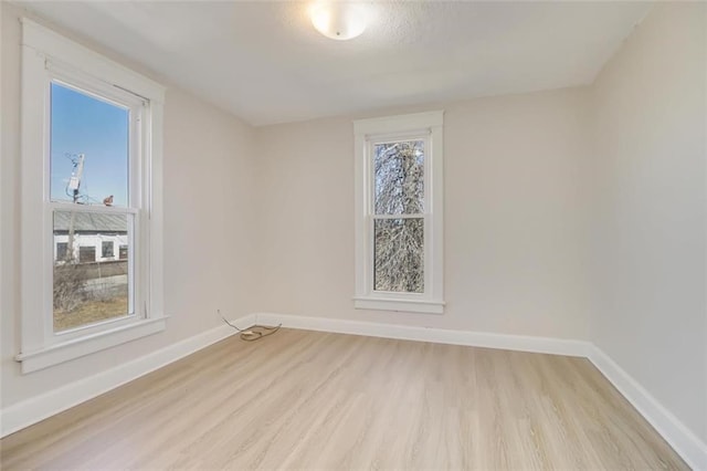 spare room featuring light wood-style flooring and baseboards