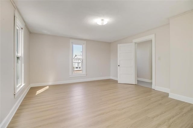 unfurnished room featuring baseboards and light wood finished floors