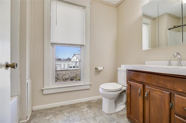 bathroom with vanity, toilet, and baseboards