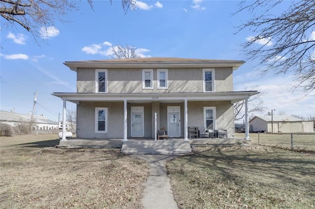 view of front facade featuring fence, a porch, and stucco siding