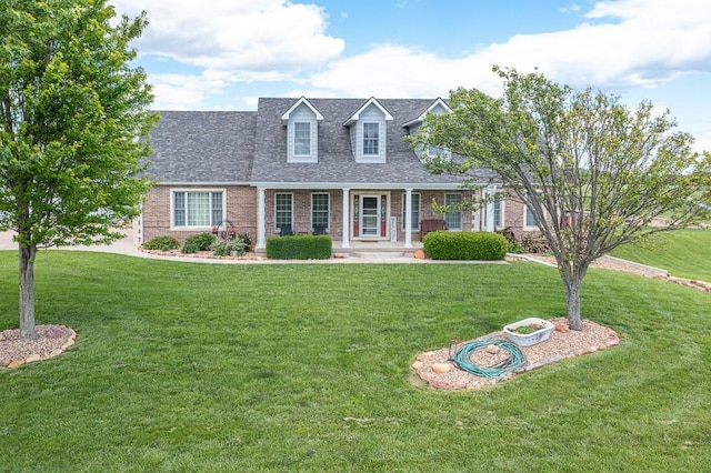22330 Mclouth Rd, Mclouth, KS 66054 - cape cod-style house with roof with shingles, a porch, a front lawn, and brick siding