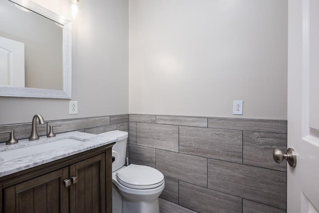 22330 Mclouth Rd, Mclouth, KS 66054 - half bath with toilet, wainscoting, tile walls, and vanity