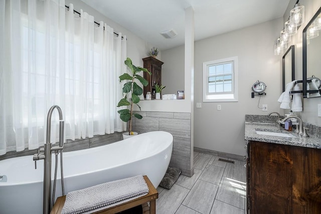 22330 Mclouth Rd, Mclouth, KS 66054 - full bathroom with a sink, visible vents, baseboards, a freestanding bath, and double vanity