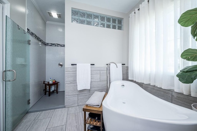 22330 Mclouth Rd, Mclouth, KS 66054 - bathroom featuring visible vents, a shower with shower door, a freestanding tub, and tile walls