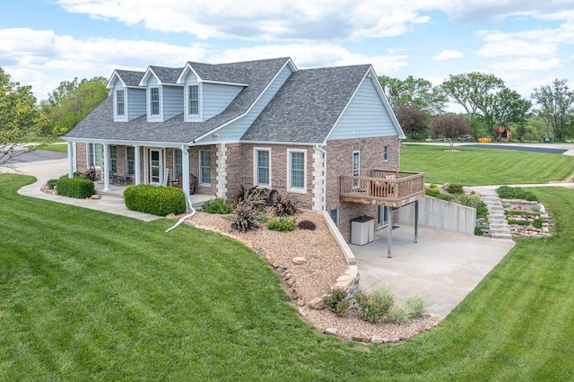 22330 Mclouth Rd, Mclouth, KS 66054 - new england style home featuring covered porch, a shingled roof, a front yard, and brick siding