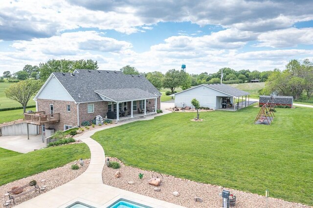 22330 Mclouth Rd, Mclouth, KS 66054 - rear view of house with a shingled roof, brick siding, a patio, and a lawn