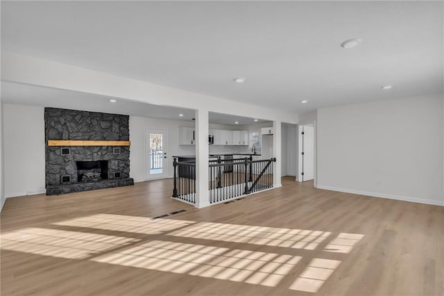 unfurnished living room with a fireplace and light hardwood / wood-style floors