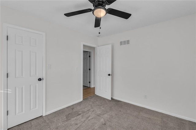 unfurnished bedroom with ceiling fan and light colored carpet