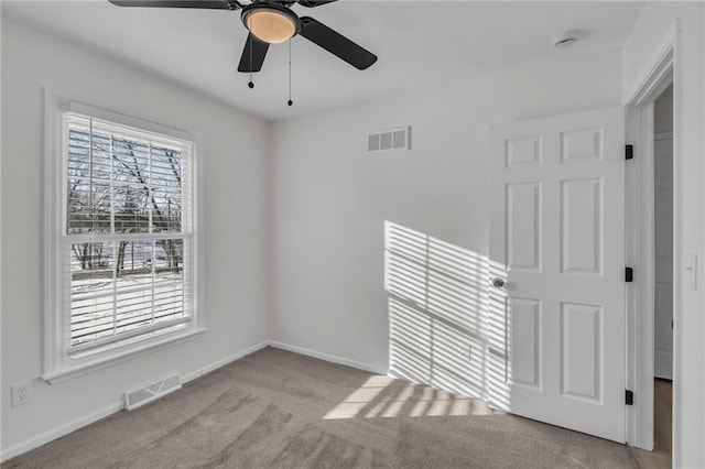 spare room featuring light carpet and ceiling fan