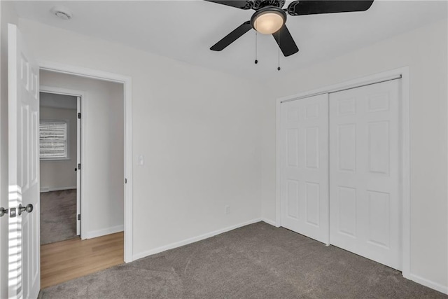 unfurnished bedroom featuring ceiling fan, a closet, and dark colored carpet