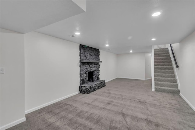 unfurnished living room with a fireplace and light colored carpet