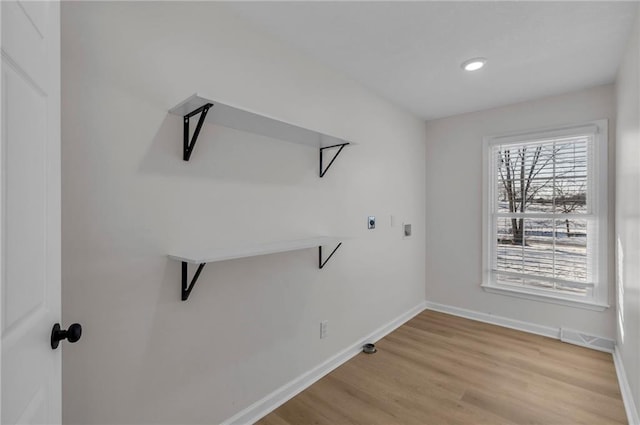 washroom featuring electric dryer hookup and light hardwood / wood-style flooring