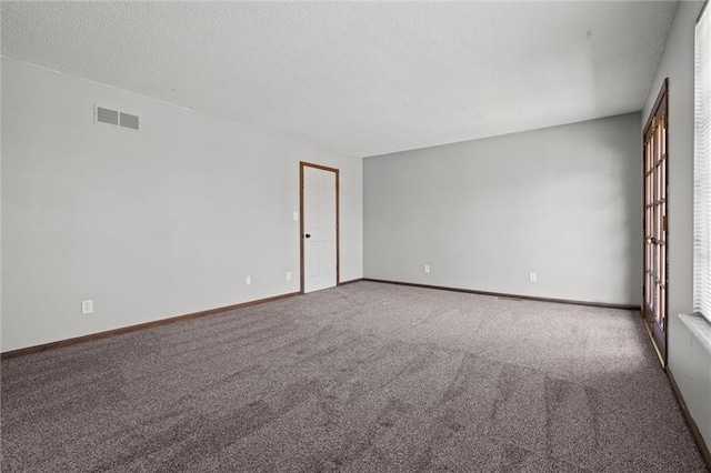 unfurnished room featuring visible vents, baseboards, a textured ceiling, and carpet