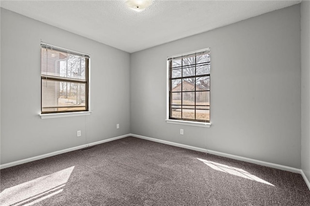 unfurnished room with baseboards, carpet floors, and a textured ceiling