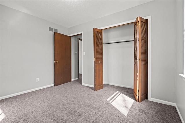 unfurnished bedroom with a closet, carpet flooring, visible vents, and baseboards