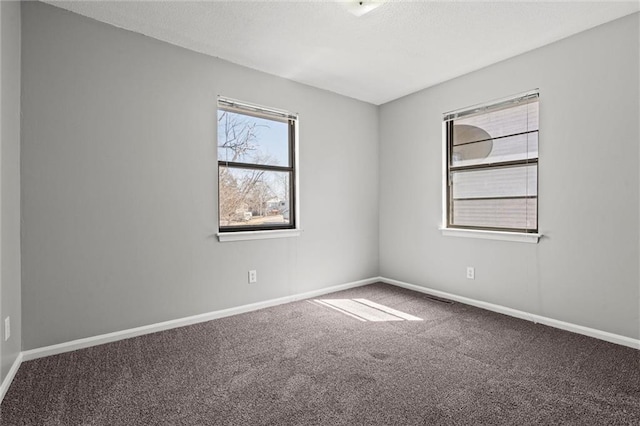 unfurnished room with carpet flooring, baseboards, and a textured ceiling