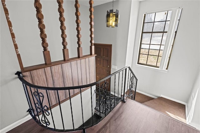 staircase featuring baseboards and wood finished floors