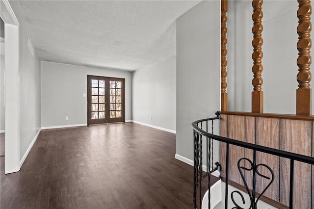 unfurnished room featuring dark wood-type flooring, baseboards, and a textured ceiling