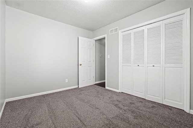 unfurnished bedroom with visible vents, a textured ceiling, a closet, carpet, and baseboards