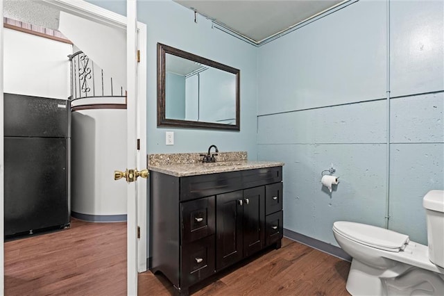 bathroom with vanity, toilet, and wood finished floors