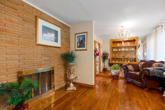 sitting room featuring a fireplace, wood finished floors, baseboards, and a chandelier