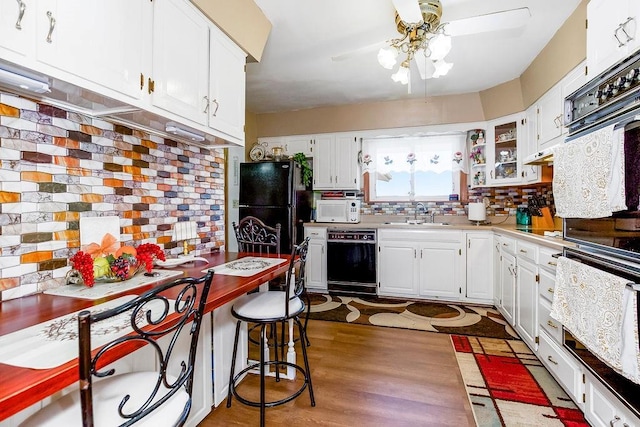 kitchen with black appliances, a ceiling fan, tasteful backsplash, white cabinets, and light countertops