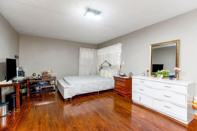 bedroom featuring wood finished floors and a textured ceiling