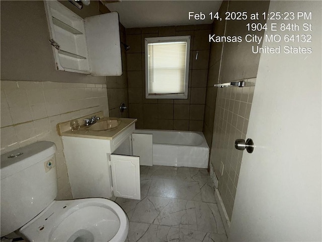 full bath featuring toilet, shower / tub combination, marble finish floor, vanity, and tile walls