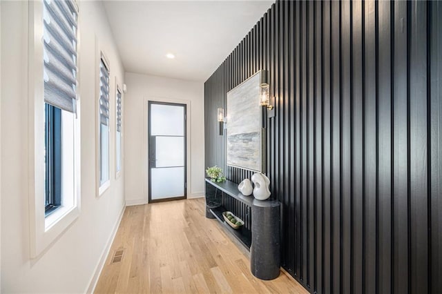 interior space featuring baseboards, light wood-type flooring, and a wealth of natural light