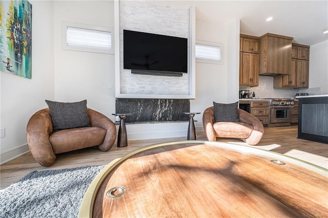 living area with recessed lighting, light wood-type flooring, and baseboards