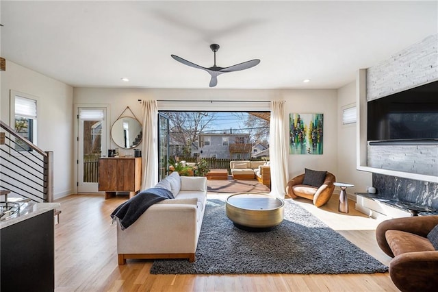 living room featuring baseboards, ceiling fan, stairway, recessed lighting, and wood finished floors