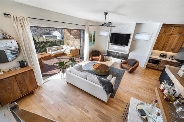 living area with light wood-style flooring and a ceiling fan