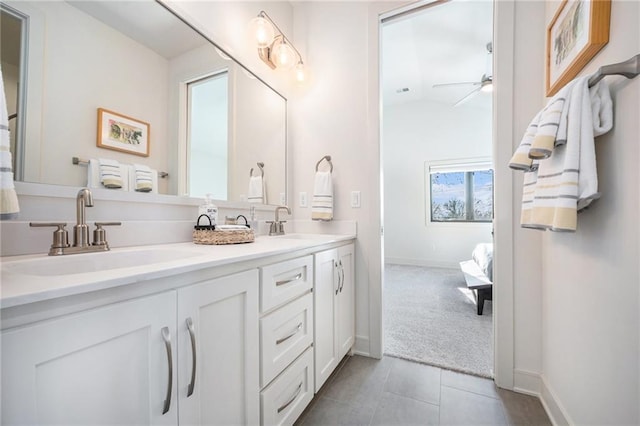 ensuite bathroom featuring double vanity, tile patterned floors, ceiling fan, and a sink