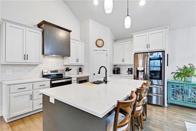 kitchen featuring stainless steel appliances, backsplash, white cabinetry, vaulted ceiling, and a sink