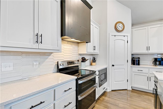 kitchen featuring light wood-style flooring, backsplash, appliances with stainless steel finishes, white cabinetry, and light stone countertops