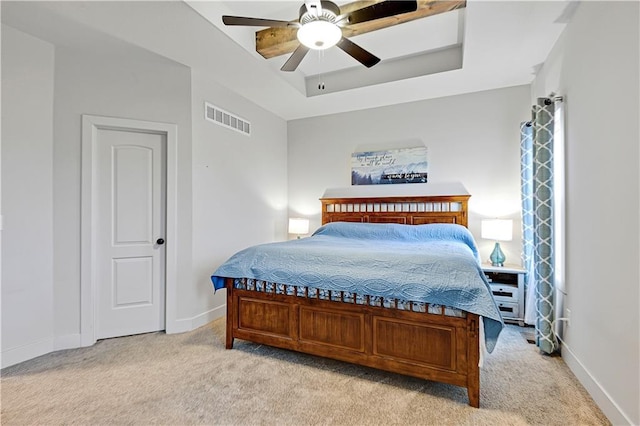 bedroom featuring light carpet, baseboards, visible vents, ceiling fan, and a tray ceiling