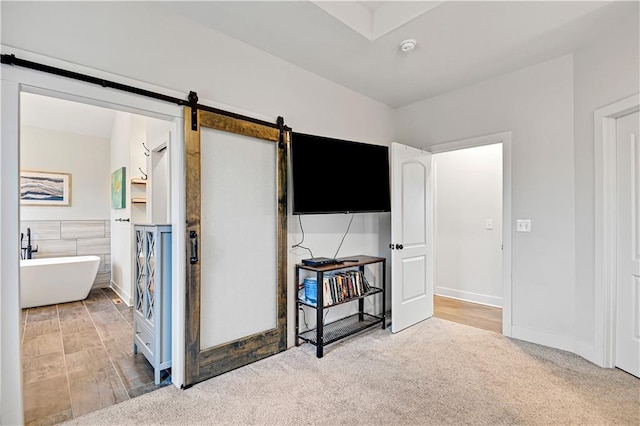 bedroom with carpet and a barn door