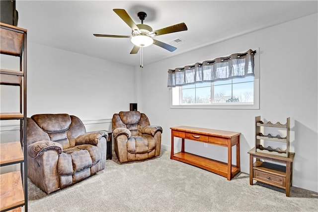 sitting room featuring a ceiling fan, carpet, and visible vents