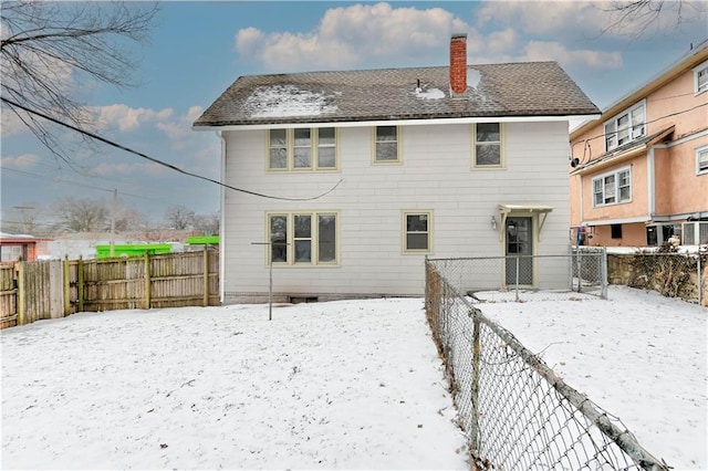 view of snow covered rear of property