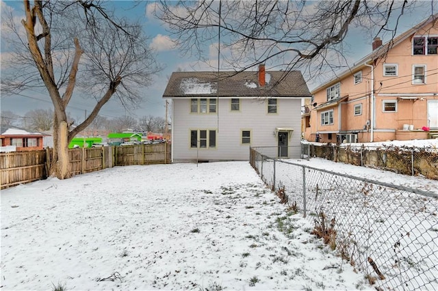 view of snow covered rear of property