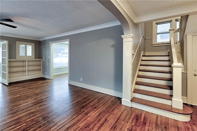 staircase featuring crown molding, plenty of natural light, hardwood / wood-style floors, and a textured ceiling