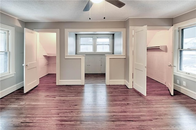 unfurnished bedroom with ceiling fan, dark hardwood / wood-style floors, and a textured ceiling