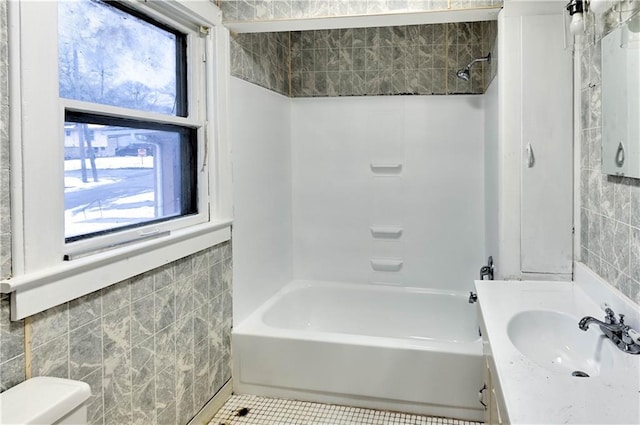 full bathroom with vanity, toilet, tub / shower combination, and tile walls