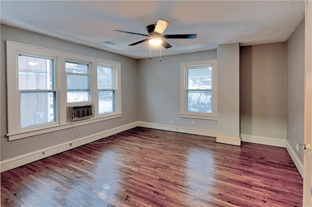 empty room featuring ceiling fan, dark wood-type flooring, and a textured ceiling