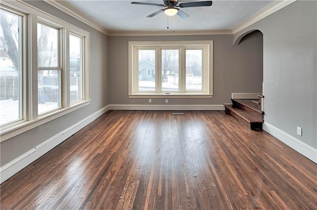 spare room featuring dark hardwood / wood-style flooring, ceiling fan, crown molding, and a textured ceiling